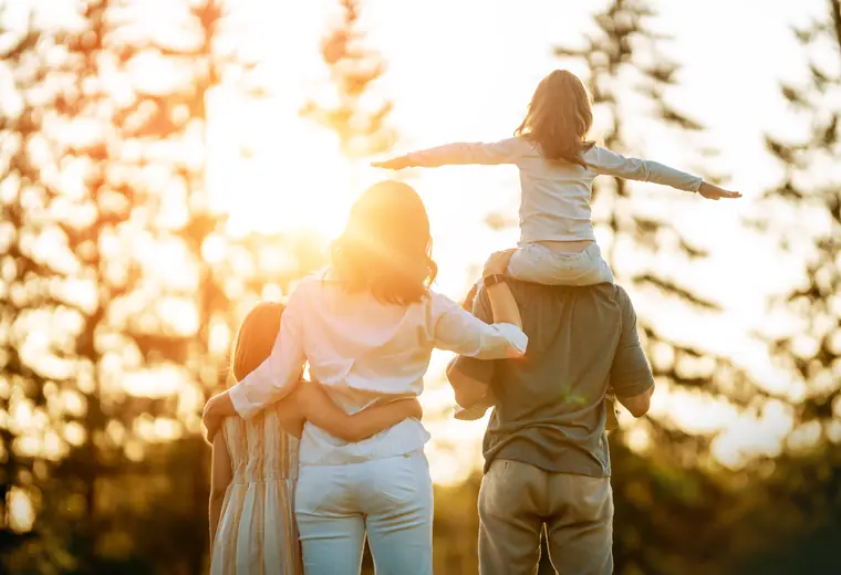 Une famille de dos regarde le jour tomber, la fille assise sur les épaules de son père — le regroupement de crédits avec hypothèque